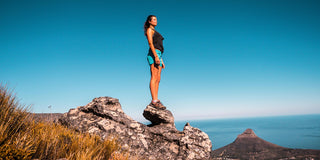 A healthy sporty woman overlooks the ocean, embracing nature.