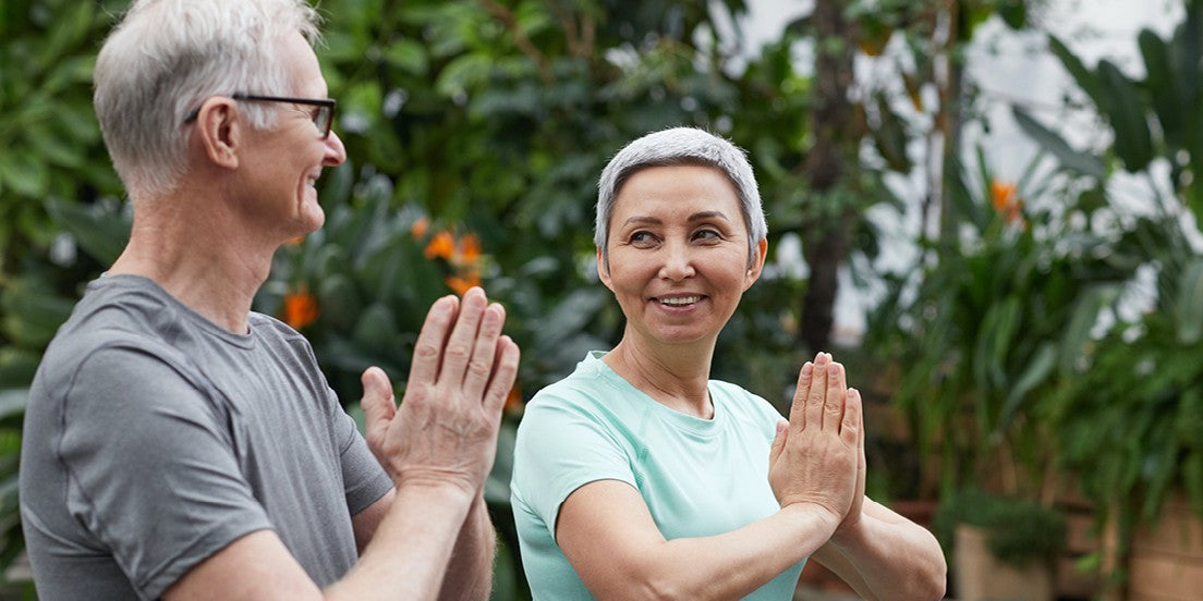 A couple practicing yoga together for wellbeing.